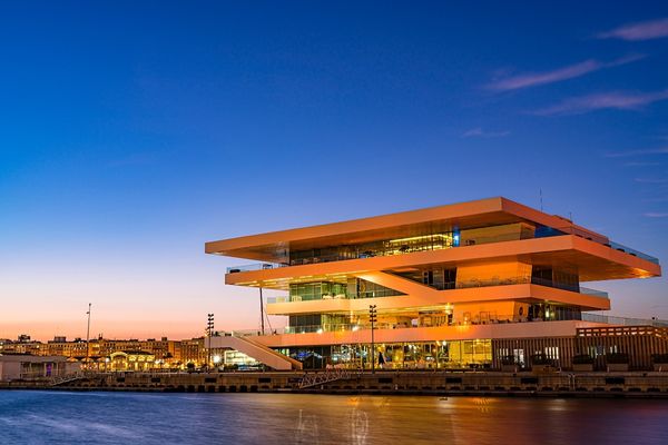 Atardecer dorado en la Marina de Valencia con el sol reflejado en el agua