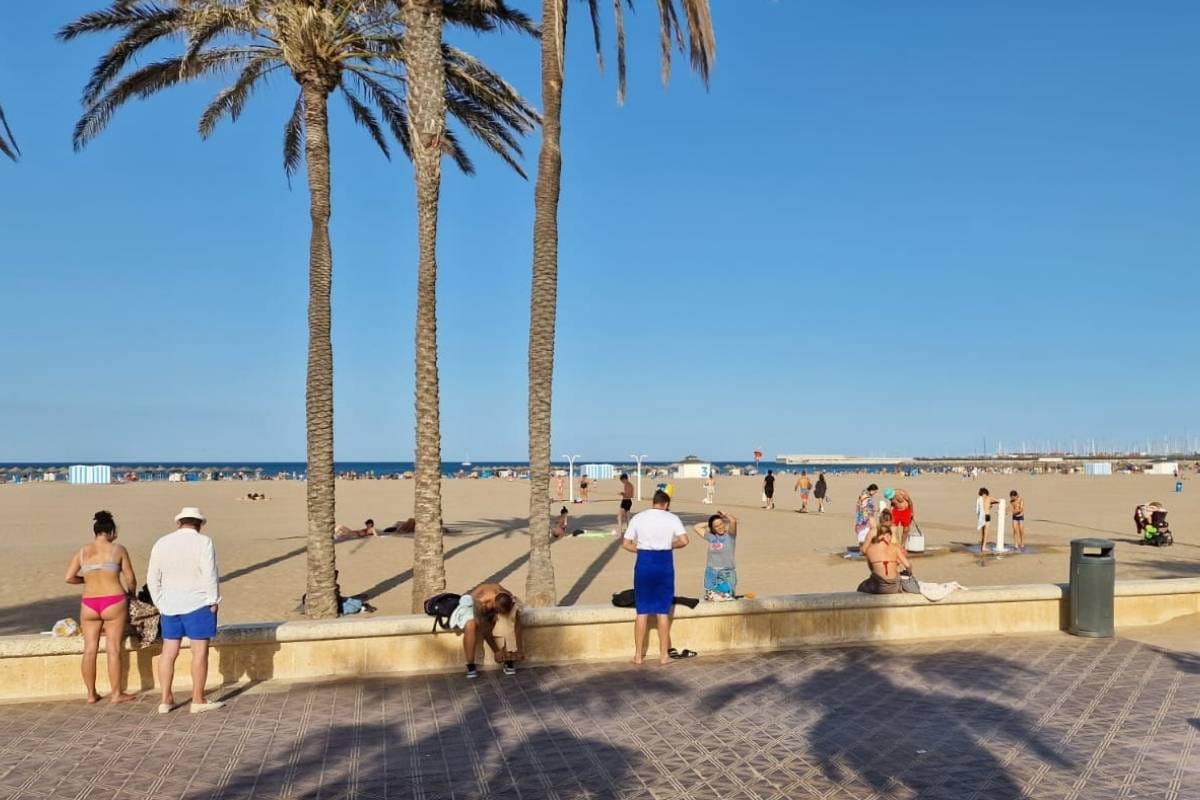 Playa de las Arenas desde el paseo marítimo de Valencia con gente disfrutando del sol y la playa